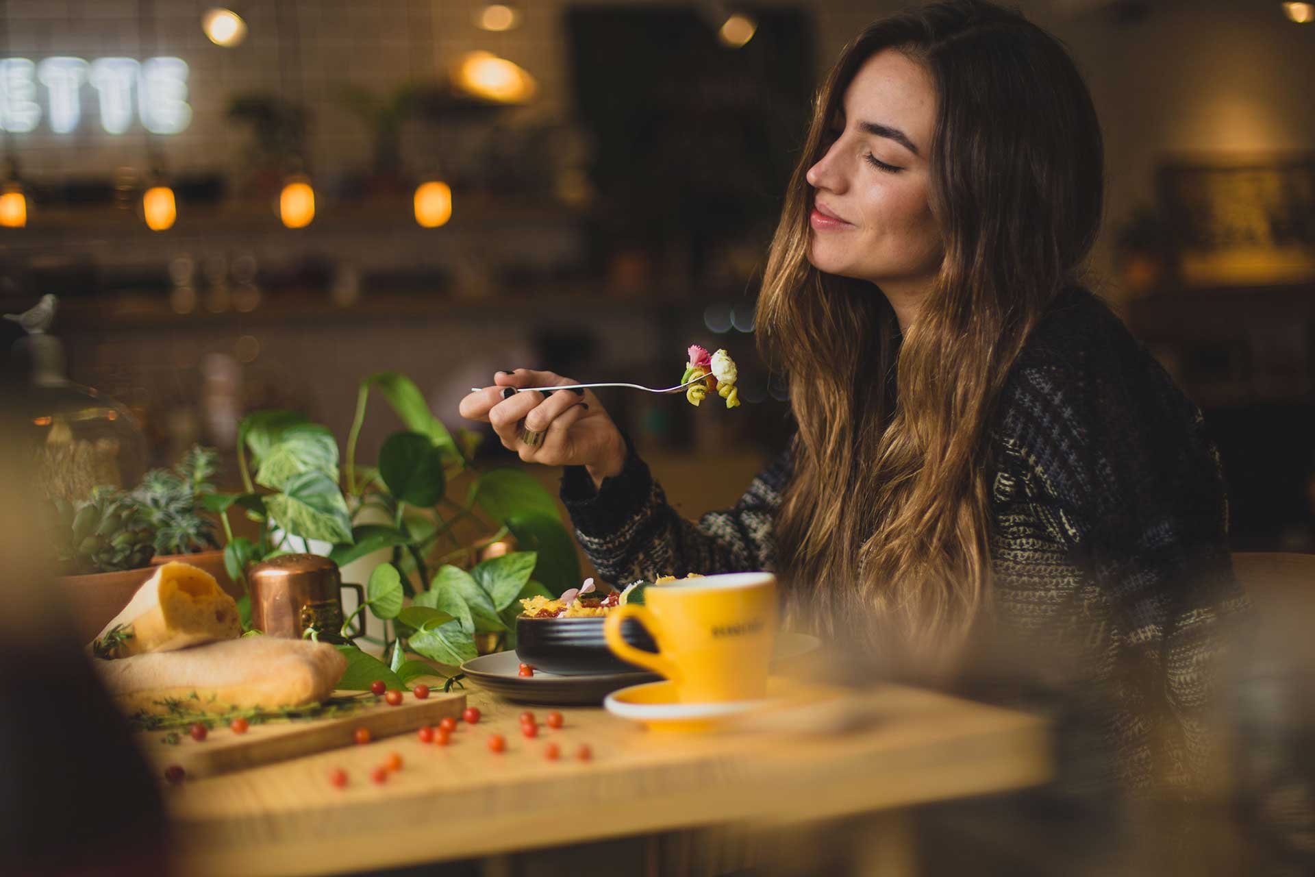 Kobieta delektująca się jedzeniem w lokalnej restauracji